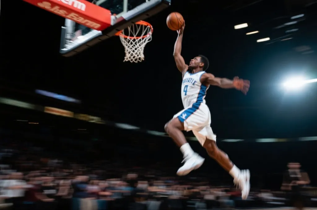 A dynamic close-up of a basketball player in mid-air about to dunk, dramatic arena lighting, high action
